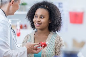 Senior doctor teaches patient to use inhaler